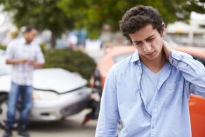 Person rubbing their neck after a car accident