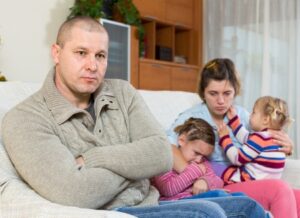 Family arguing, husband crossing his arms and looking upset